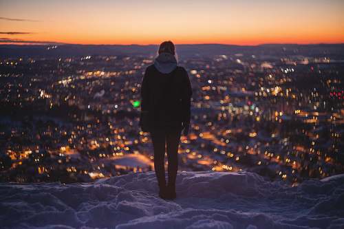 people person standing on mountain looking on lights person
