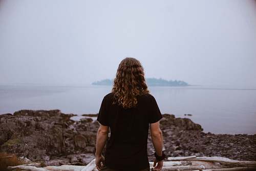 people person standing on rocky shore during daytime person