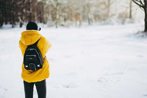 people person wearing coat standing on field of snow during daytime person