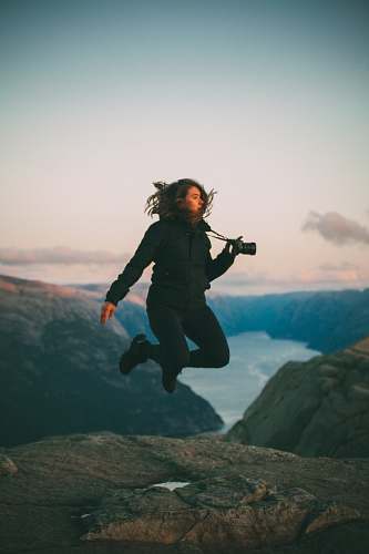people selective focus photo of woman jumping holding camera person
