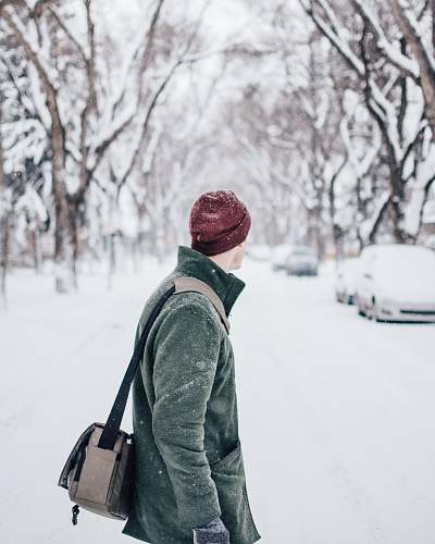 people selective focus photography of man wearing coat and beanie standing watching vehicle on road person