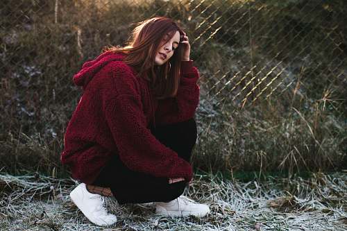 people selective focus photography of woman half-sitting near fence person