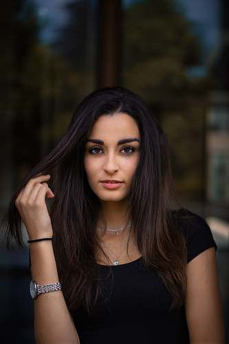 people selective focus photography of woman holding her hair while smiling person