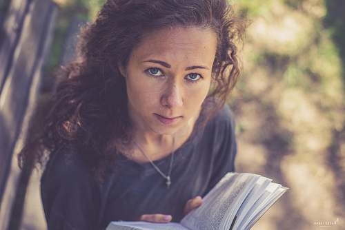 people selective focus photography of woman reading book person