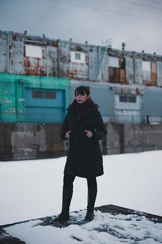 people selective focus photography of woman wearing overcoat standing on intermodal container person