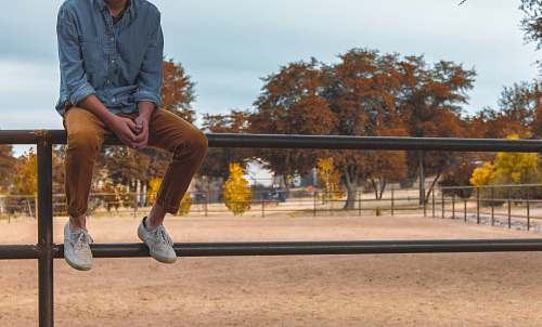 person shallow focus photography of person sitting on rail way people