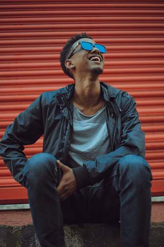 people smiling man sitting on concrete floor person