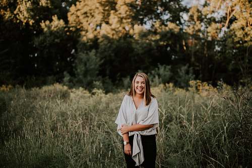 people standing woman smiling near trees at daytime person