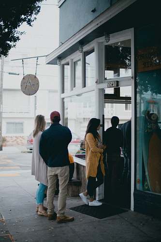 people three people standing near glass door person