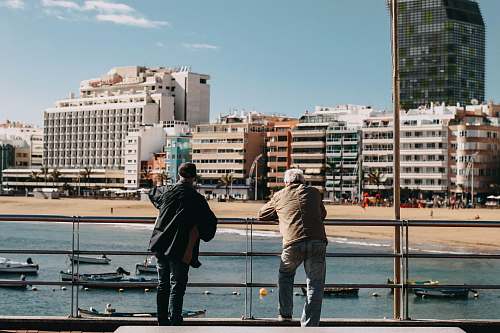 people two men leaning on metal rails person