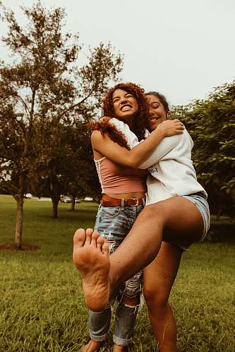 people two woman standing near tree photo person