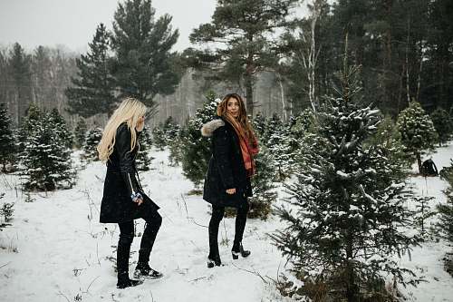female two woman walking towards snow woman