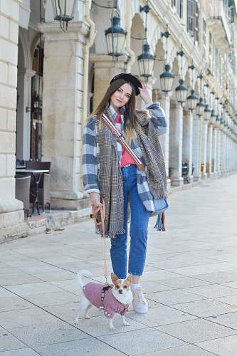 person woman and puppy standing beside building people
