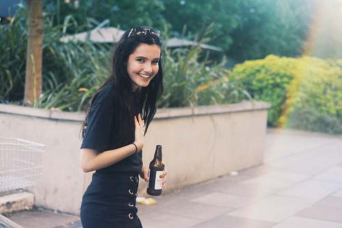 person woman holding black bottle in rule of thirds photography people