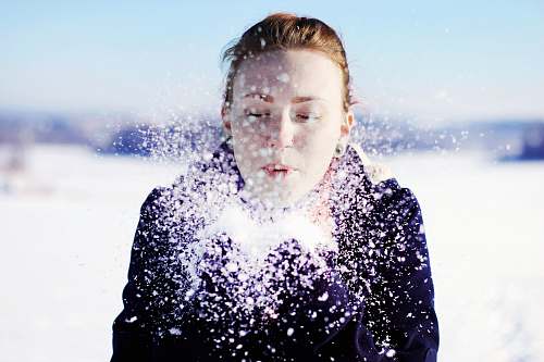 people woman in black jacket blowing snow person