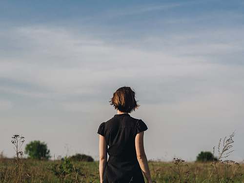 people woman in black shirt standing in grass field person
