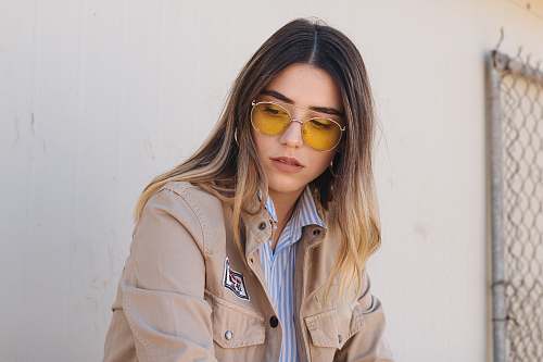 people woman in brown button-up jacket near white painted wall person