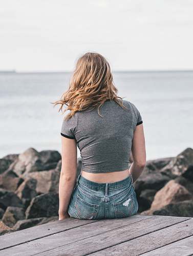 person woman in gray top sitting on dock people