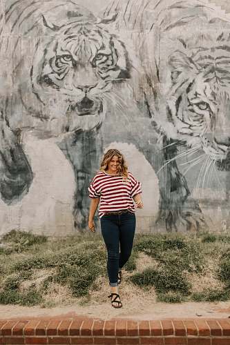 people woman in standing beside tiger-printed wall person
