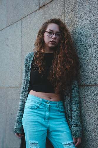 people woman leaning on gray wall tiles person