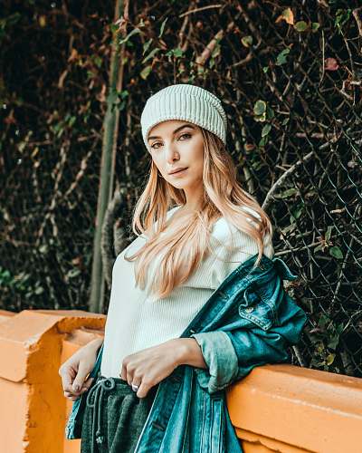 people woman leaning on orange fence while looking straight to the camera person