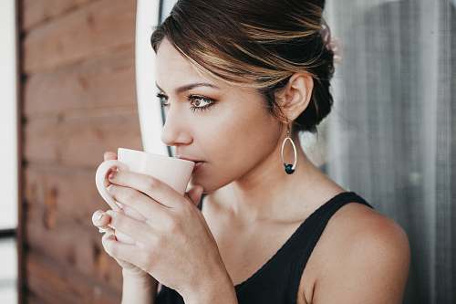 people woman leaning on wall drinking coffee person