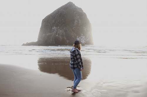 person woman seashore beside hill people