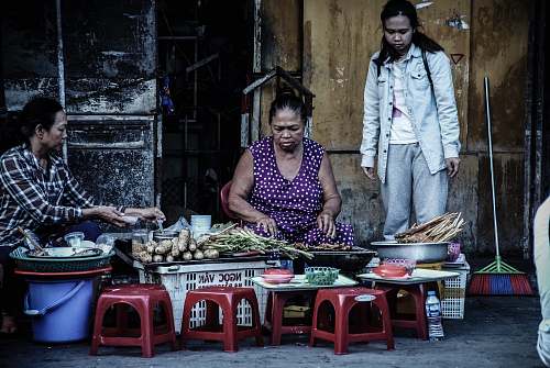 people woman sitting in front vegetables beside two women person