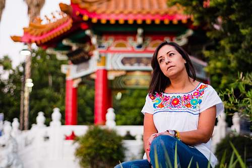 people woman sitting near gazebo and green plants person