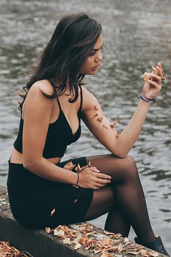 person woman sitting next to body of water people
