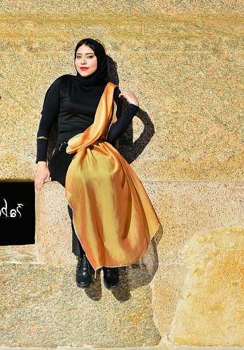 people woman sitting on beige concrete surface at daytime person