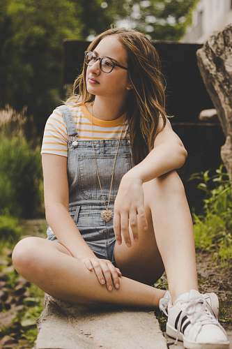 people woman sitting on concrete pavement person