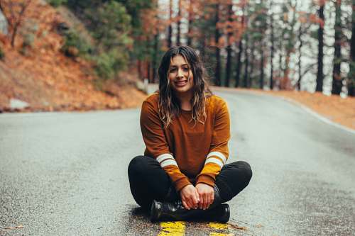 person woman sitting on concrete road people