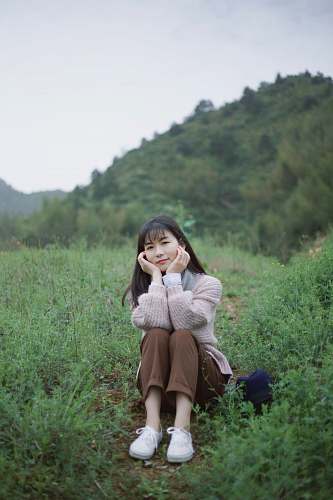 people woman sitting on green grass person