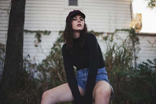 people woman sitting on stool near house during daytime person