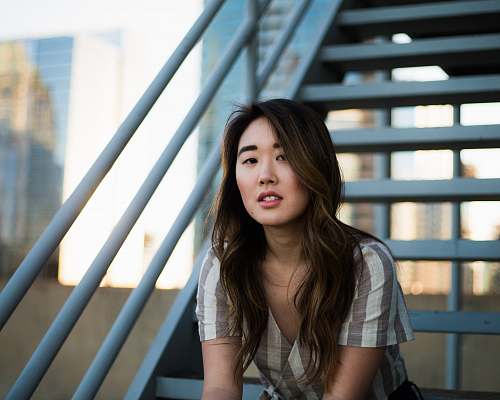 people woman sitting on white metal stairs woman