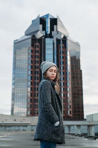 people woman standing behind high rise building during daytime person
