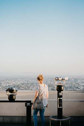 people woman standing beside telescope during daytime person