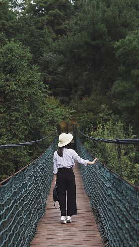 people woman standing in between brown and green bridge person