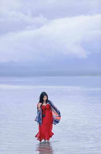 people woman standing in body of water at daytime person