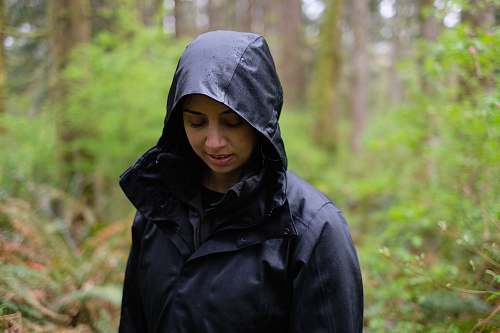 people woman standing in forest while looking at the ground person