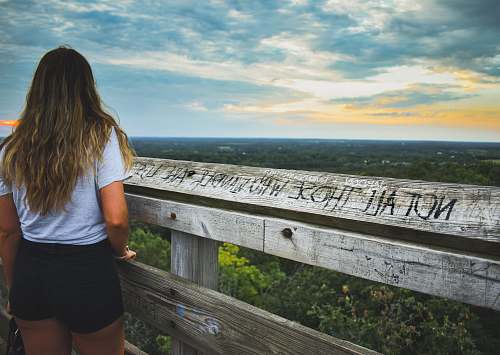 person woman standing in front of wooden fence people