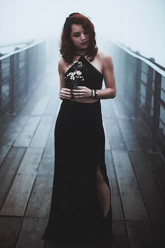 people woman standing in the bridge while holding flowers person
