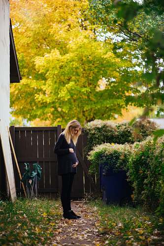 female woman standing near brown wooden fence woman