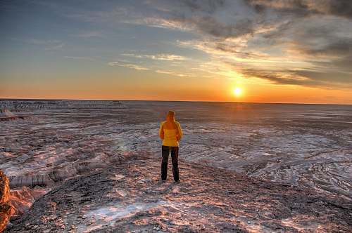 person woman standing on brown cliff people