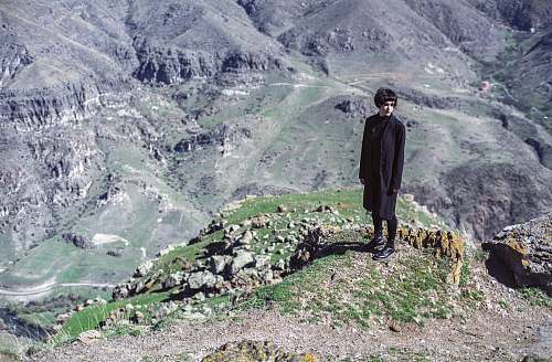 people woman standing on cliff wearing black suit person
