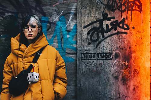 people woman standing on gray graffiti wall person