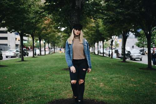 people woman standing on green grass in between of green leafed trees person