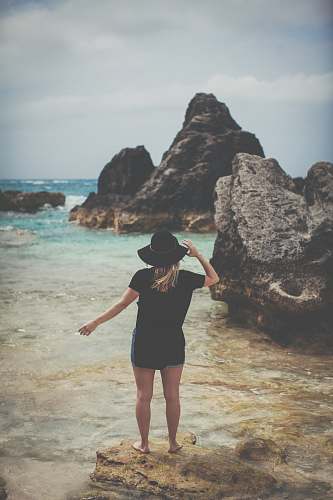 people woman standing on rock seeing body of water person