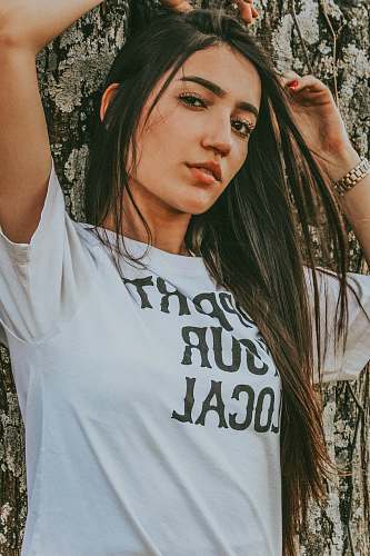 people woman standing while wearing white t-shirt person